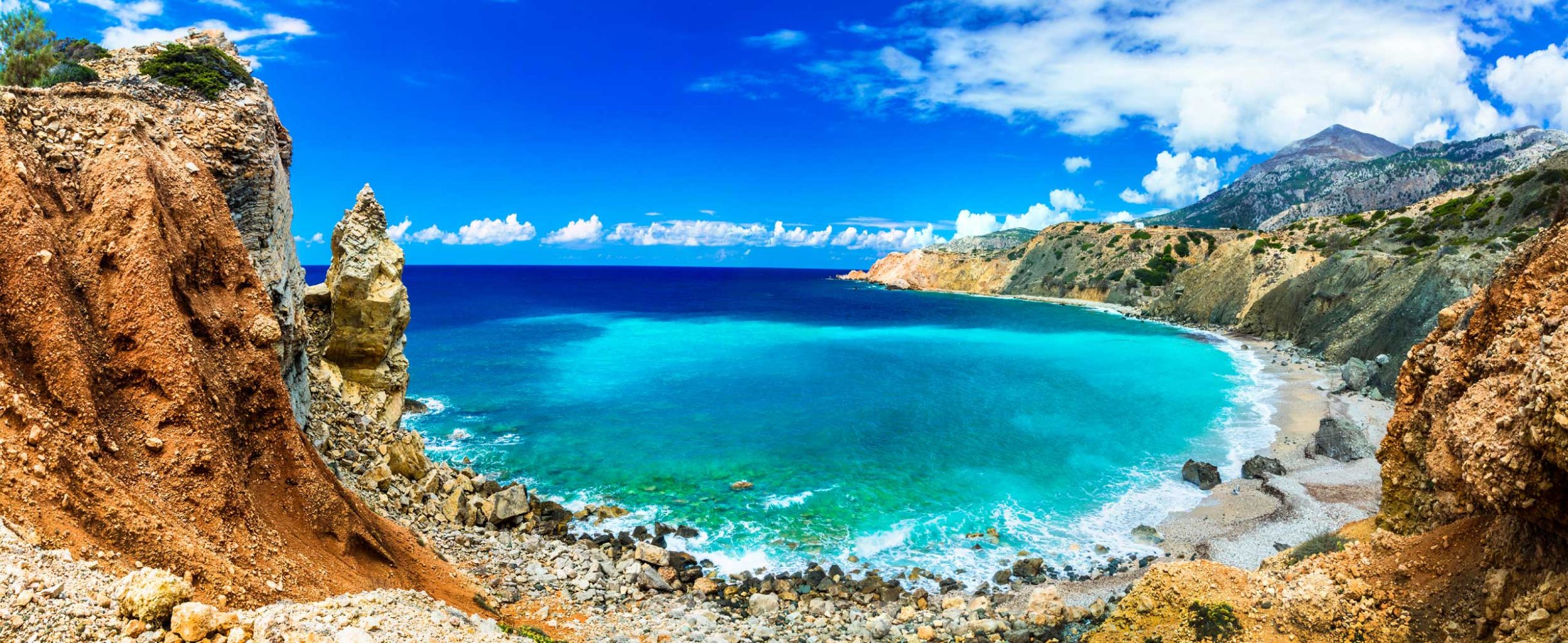 A luxury yacht sailing on clear blue water near a coastline.